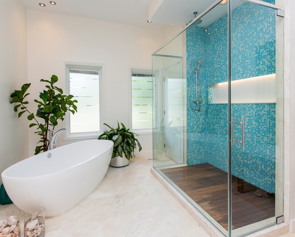 Photo of a mid-sized contemporary master bathroom in Other with flat-panel cabinets, white cabinets, a freestanding tub, an alcove shower, a one-piece toilet, blue tile, glass tile and white walls.