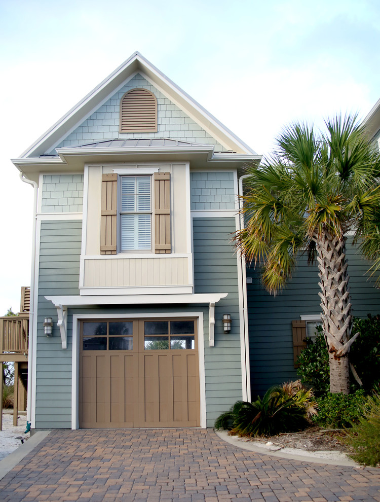 Mid-sized beach style two-storey green exterior in Miami with concrete fiberboard siding and a gable roof.