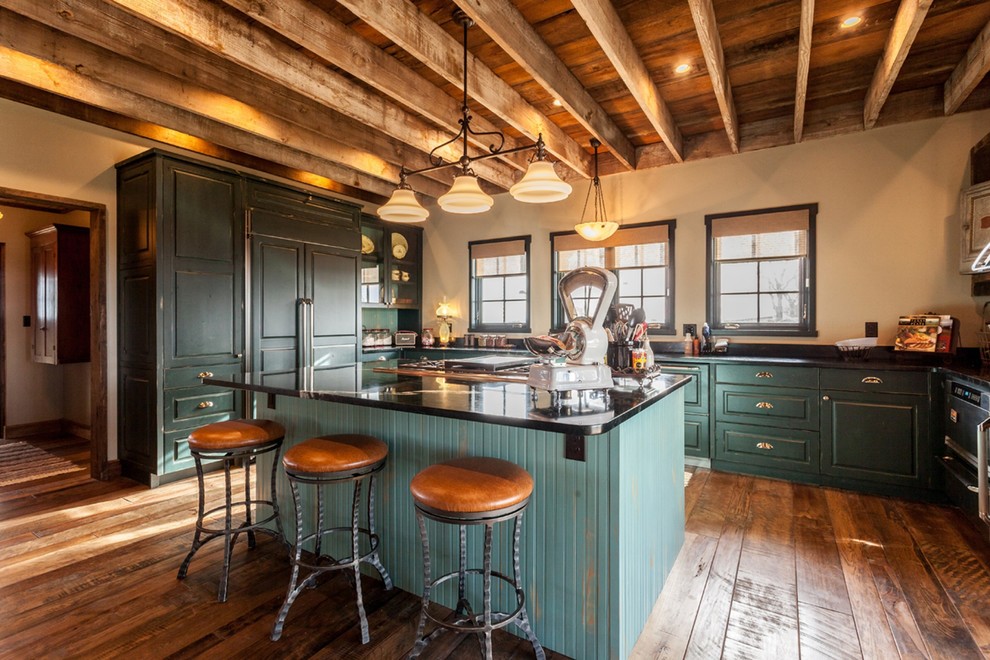 Large country u-shaped separate kitchen in Austin with soapstone benchtops, with island, raised-panel cabinets, green cabinets, panelled appliances and dark hardwood floors.