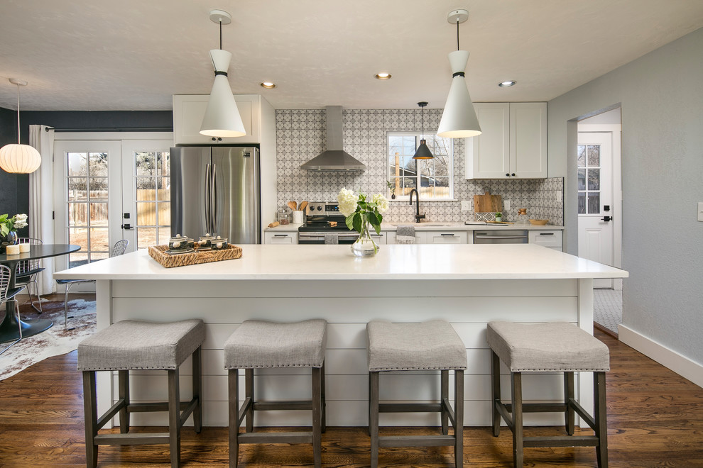 Inspiration for a transitional galley eat-in kitchen in Denver with an undermount sink, shaker cabinets, white cabinets, grey splashback, porcelain splashback, stainless steel appliances, medium hardwood floors, with island, brown floor and white benchtop.