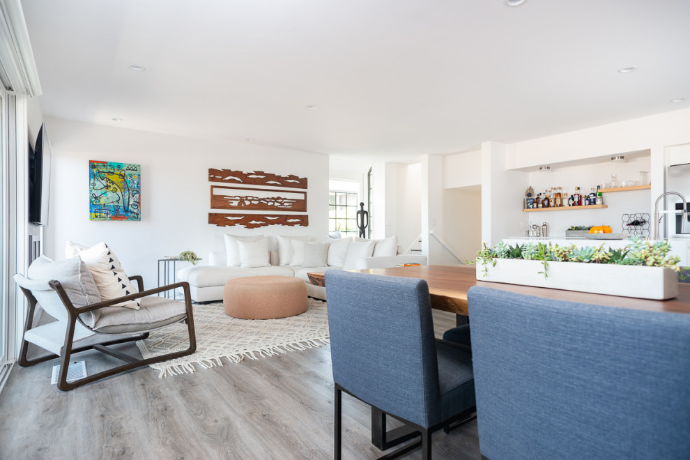 Immagine di un grande soggiorno moderno aperto con pareti bianche, pavimento in vinile, pavimento grigio, angolo bar, nessun camino e TV a parete