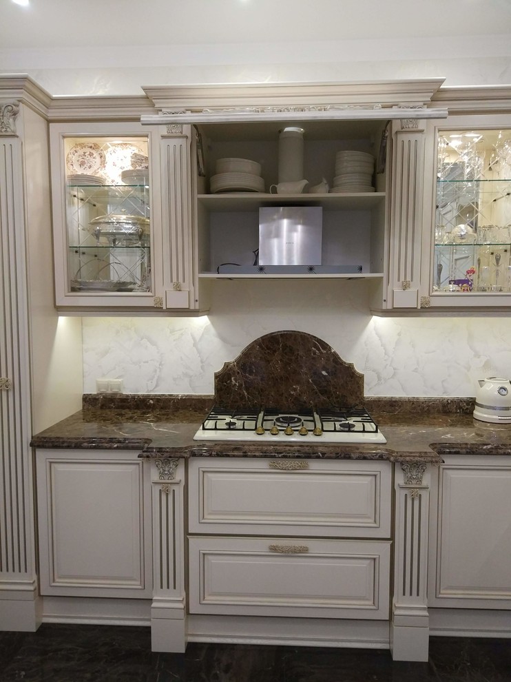 Traditional l-shaped eat-in kitchen in Other with an integrated sink, raised-panel cabinets, marble benchtops and no island.