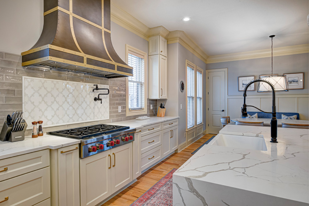 Inspiration for a mid-sized transitional l-shaped medium tone wood floor and beige floor enclosed kitchen remodel in Indianapolis with an undermount sink, shaker cabinets, white cabinets, granite countertops, gray backsplash, subway tile backsplash, stainless steel appliances, an island and white countertops