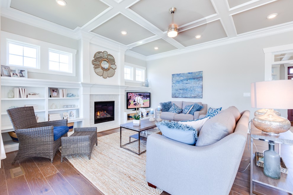 Photo of a large beach style open concept living room in Other with grey walls, medium hardwood floors, a standard fireplace, a tile fireplace surround and a built-in media wall.