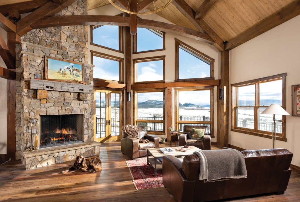 Country formal open concept living room in Other with white walls, medium hardwood floors, a standard fireplace, a stone fireplace surround, no tv, brown floor, exposed beam, vaulted and wood.