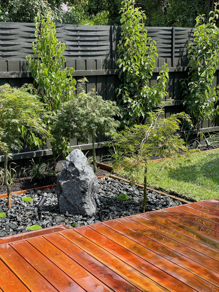 Inspiration for a mid-sized asian backyard full sun formal garden in Melbourne with with rock feature and decking.