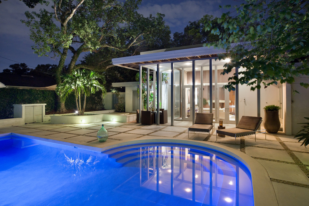 Contemporary custom-shaped pool in Orlando with concrete pavers.