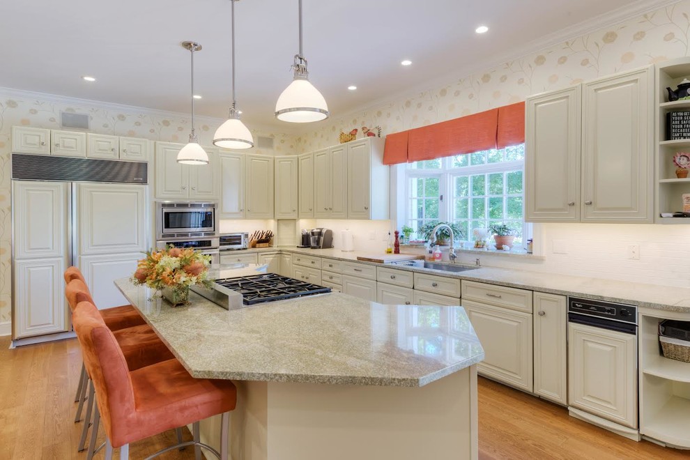 Transitional medium tone wood floor kitchen photo in Boston with an undermount sink, raised-panel cabinets, granite countertops, white backsplash, paneled appliances, an island and white cabinets