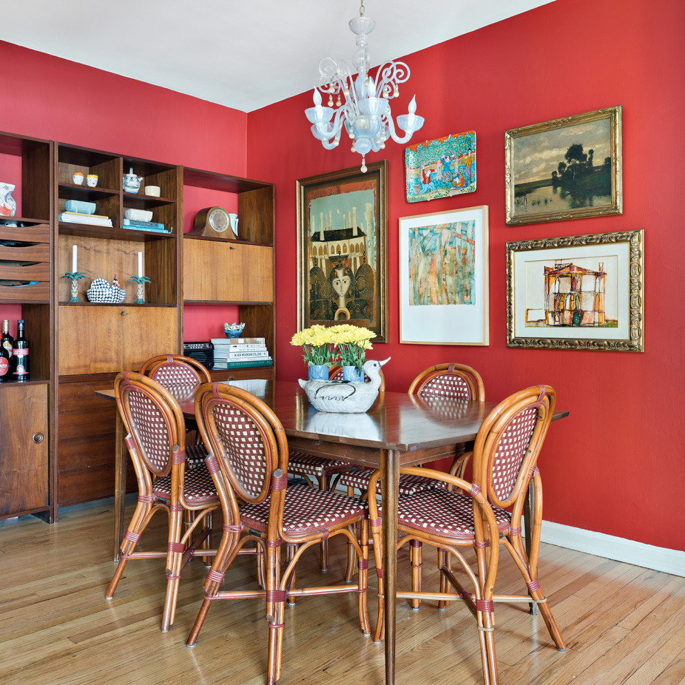 Diseño de comedor bohemio con paredes rojas y suelo de madera clara