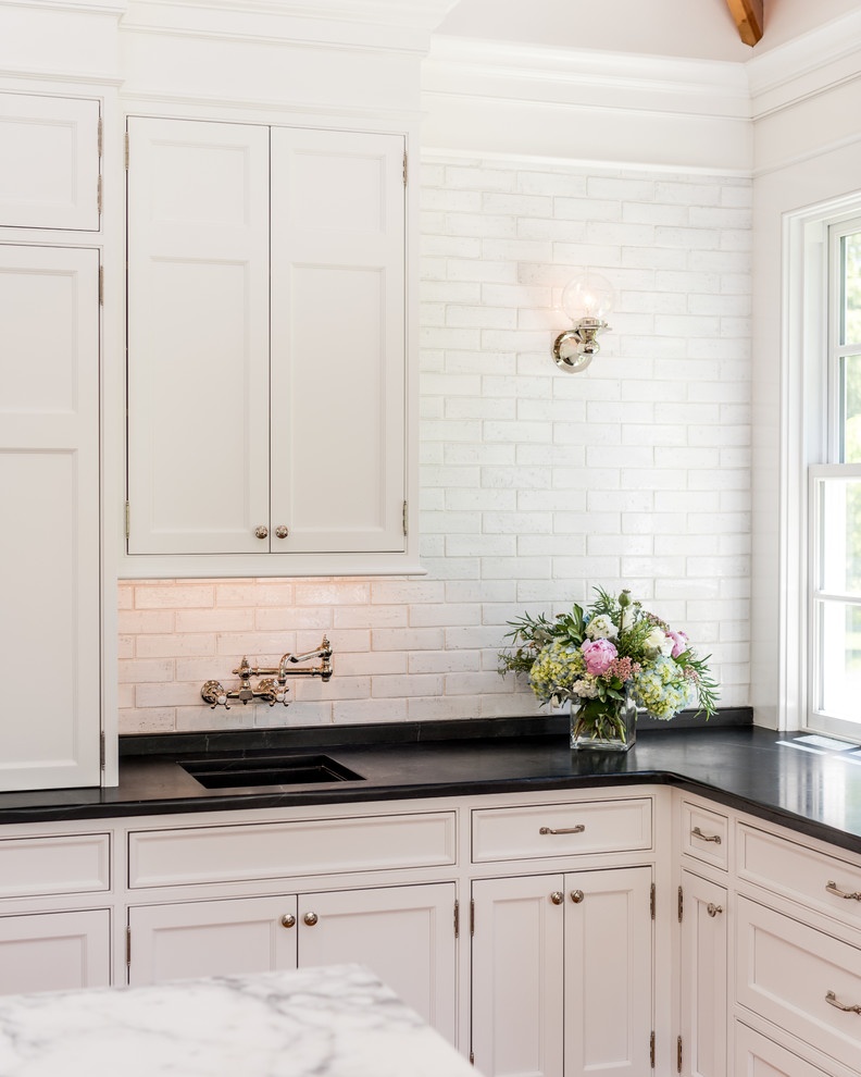 Inspiration for an expansive traditional u-shaped separate kitchen in Philadelphia with a farmhouse sink, beaded inset cabinets, white cabinets, soapstone benchtops, white splashback, coloured appliances, light hardwood floors, with island and subway tile splashback.
