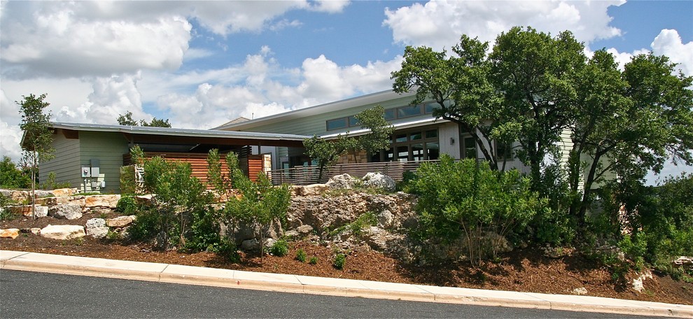 This is an example of a large modern two-storey exterior in Austin with wood siding.