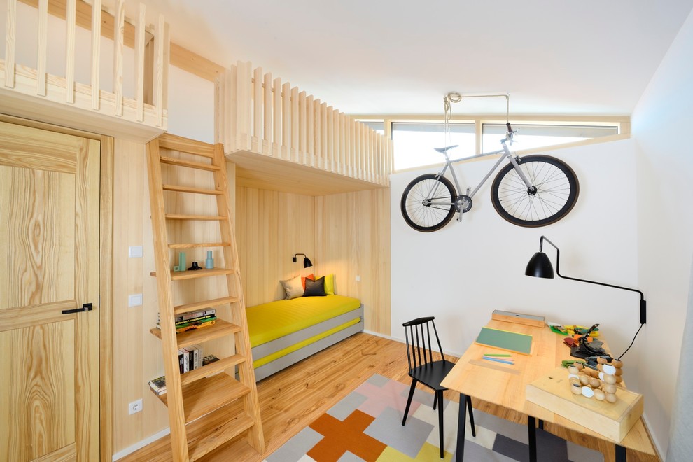 Design ideas for a mid-sized scandinavian gender-neutral kids' room in Other with white walls and light hardwood floors.