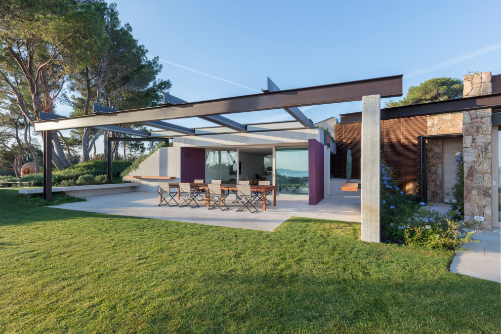 Esempio di un ampio patio o portico minimalista davanti casa con una pergola
