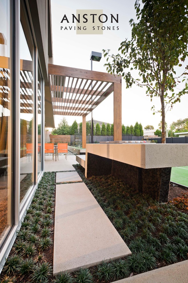 Photo of a contemporary patio in Melbourne with an outdoor kitchen, concrete pavers and a pergola.