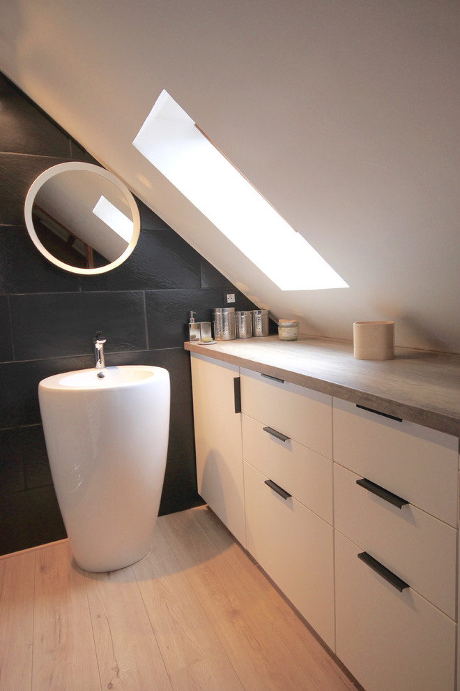 This is an example of a small modern 3/4 bathroom in Paris with beaded inset cabinets, white cabinets, an alcove shower, black tile, slate, black walls, laminate floors, a drop-in sink, laminate benchtops, beige floor and a hinged shower door.