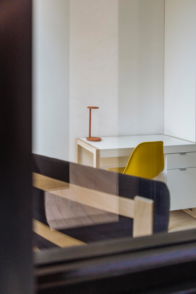 Ejemplo de habitación infantil unisex de 4 a 10 años escandinava con escritorio, paredes blancas, suelo de madera clara y suelo beige