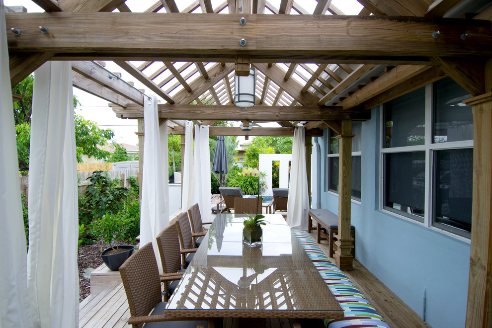 Inspiration for a mid-sized tropical side yard patio in Miami with a pergola.