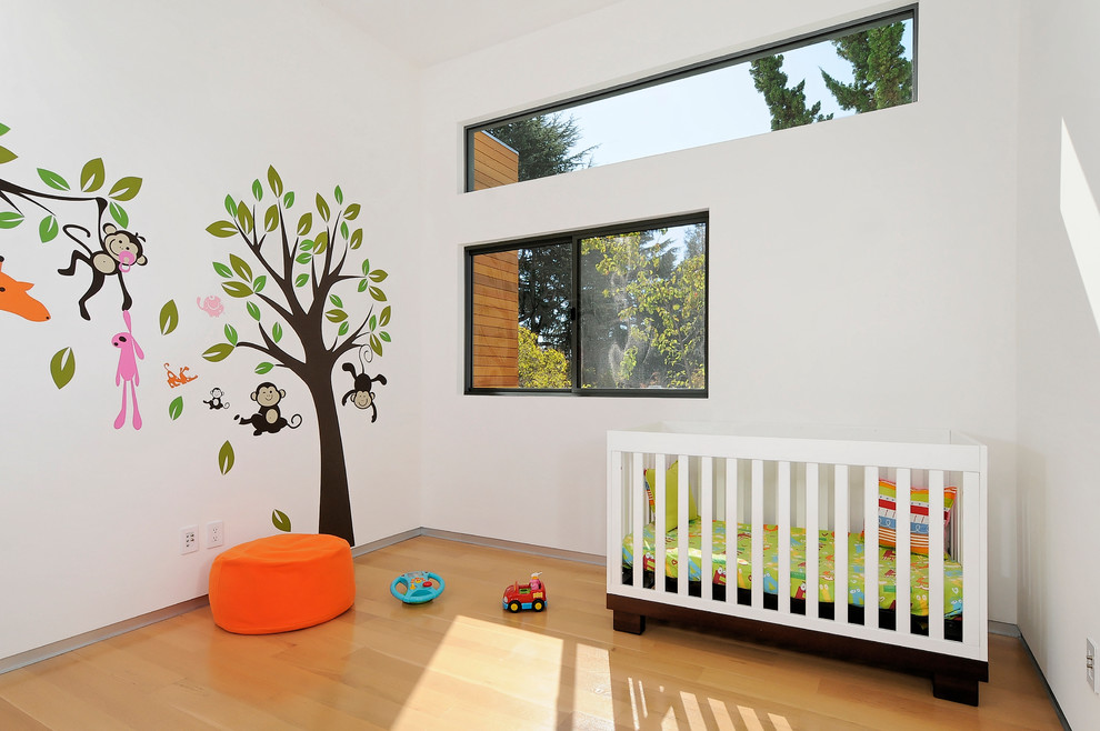 Design ideas for a contemporary gender-neutral kids' room in San Francisco with white walls and light hardwood floors.