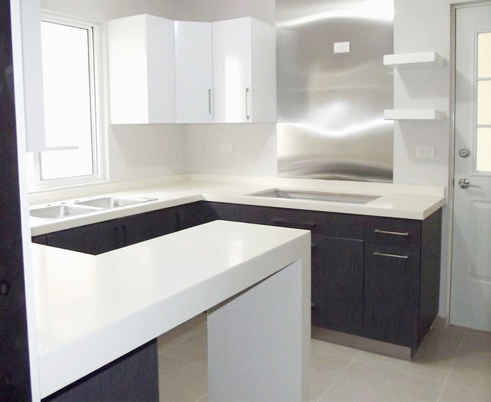 Small minimalist u-shaped porcelain tile eat-in kitchen photo with a double-bowl sink, flat-panel cabinets, dark wood cabinets, solid surface countertops, metallic backsplash, metal backsplash, black appliances and a peninsula
