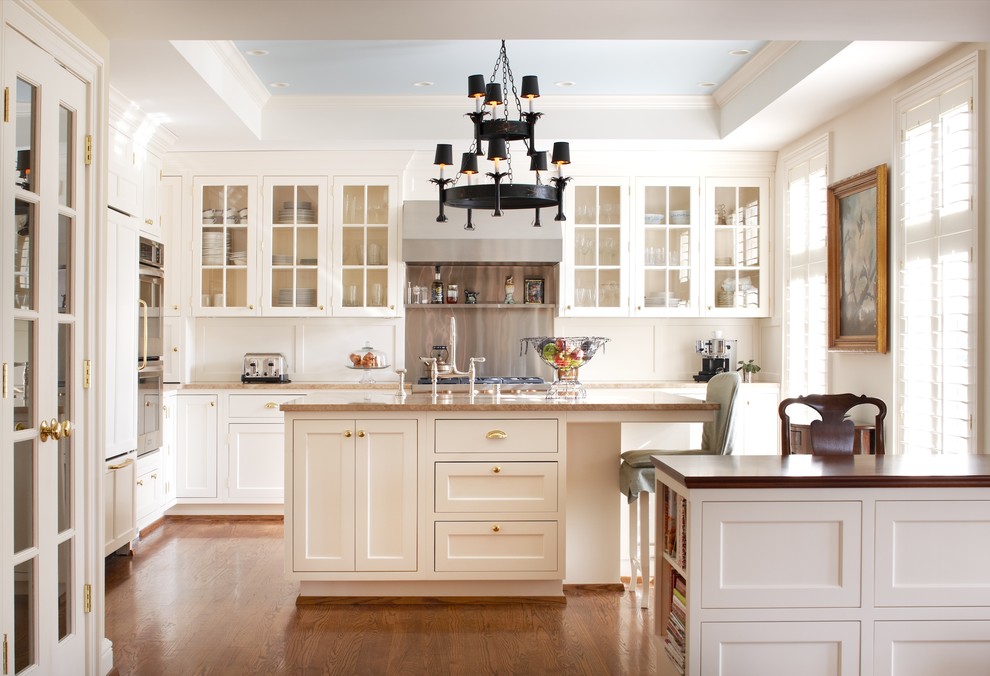This is an example of a traditional kitchen in Louisville with glass-front cabinets, white cabinets and panelled appliances.