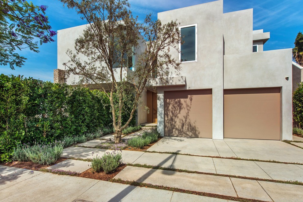 This is an example of a mid-sized modern two-storey concrete beige house exterior in Los Angeles with a flat roof.