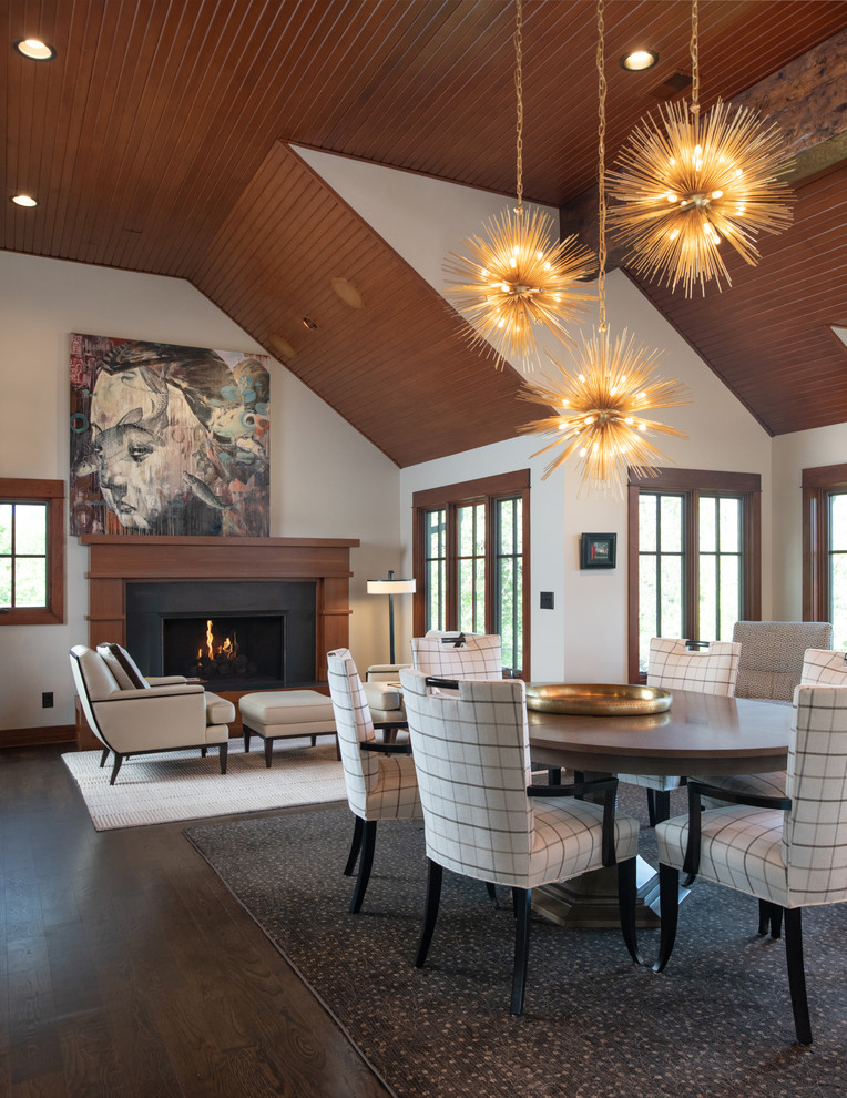 This is an example of a country dining room in Kansas City with white walls, dark hardwood floors, a standard fireplace and brown floor.