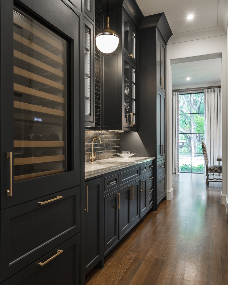 Design ideas for a transitional single-wall wet bar in Dallas with shaker cabinets, black cabinets, black splashback, subway tile splashback, dark hardwood floors, brown floor and grey benchtop.