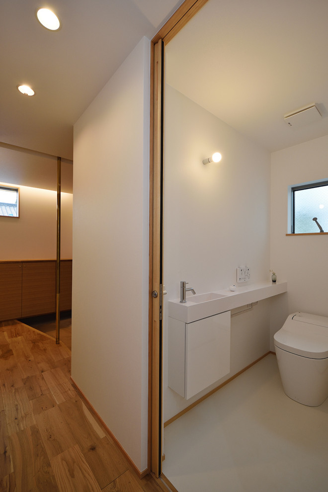 Idée de décoration pour un petit WC et toilettes nordique avec un mur blanc, un sol en vinyl, un sol gris, un plafond en papier peint et du papier peint.