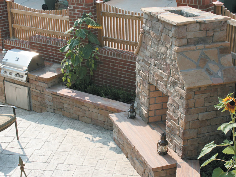 Photo of a mid-sized traditional backyard patio in Toronto with an outdoor kitchen, stamped concrete and no cover.