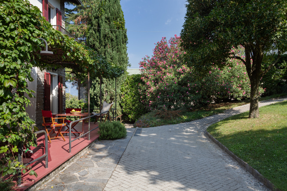 На фото: большая пергола во дворе частного дома на заднем дворе в стиле ретро с зоной барбекю и мощением тротуарной плиткой