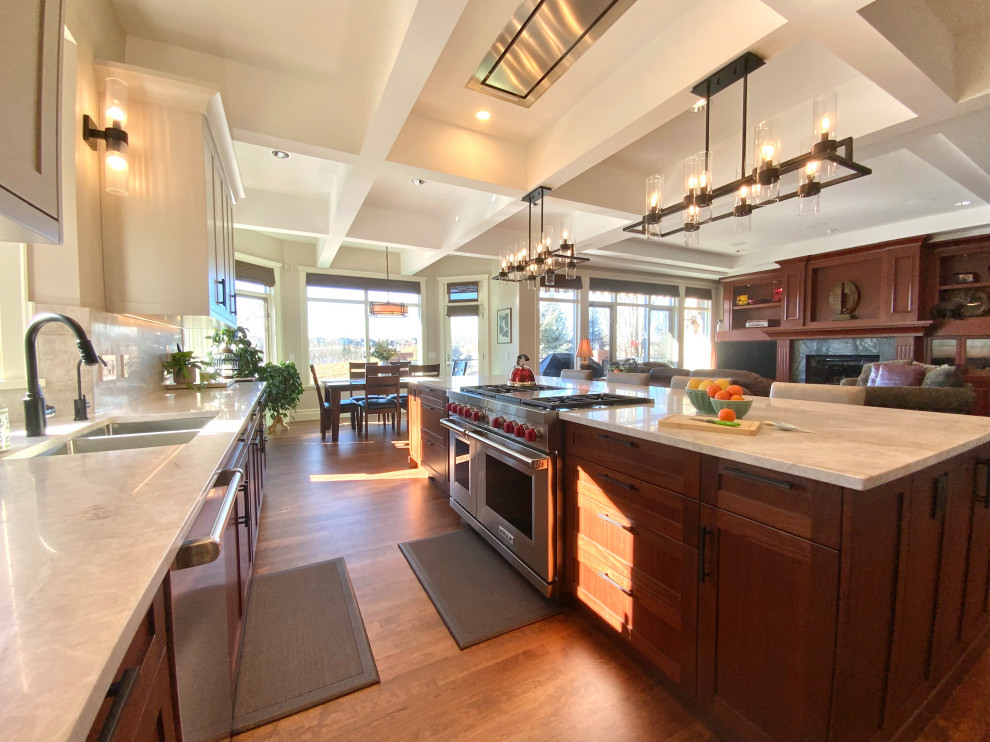 Example of a large transitional single-wall dark wood floor, brown floor and coffered ceiling eat-in kitchen design in Calgary with an undermount sink, shaker cabinets, quartzite countertops, white backsplash, stainless steel appliances, an island and white countertops