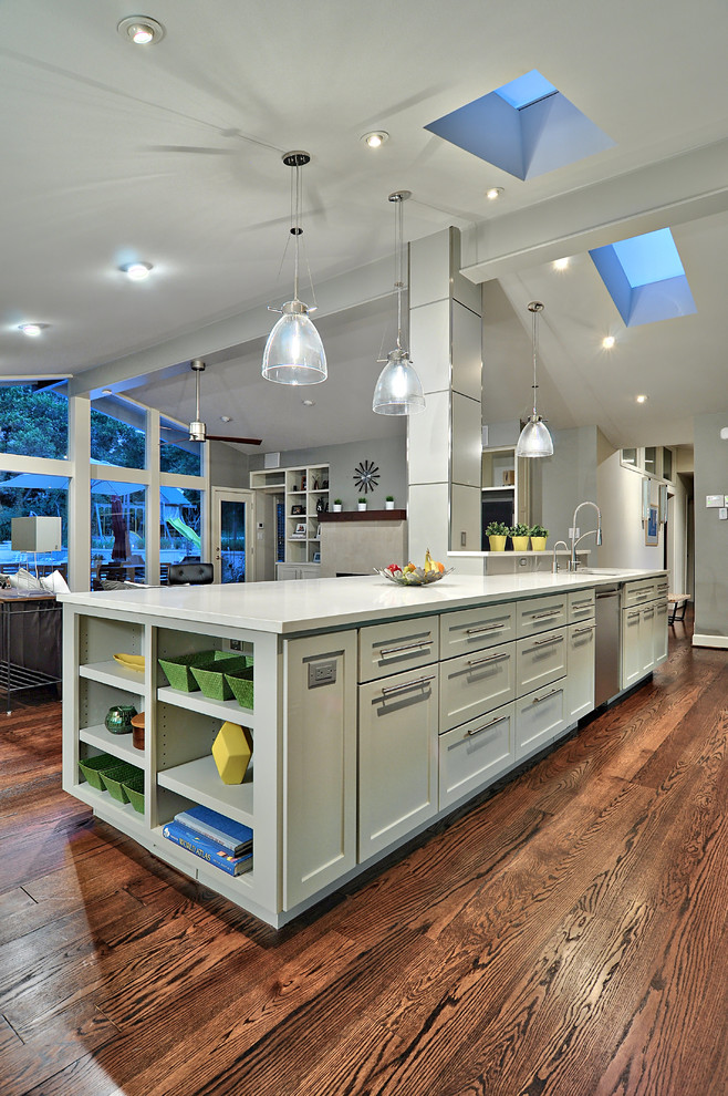 Example of a mid-sized transitional dark wood floor open concept kitchen design in Austin with shaker cabinets, gray cabinets, stainless steel appliances, quartz countertops and an island