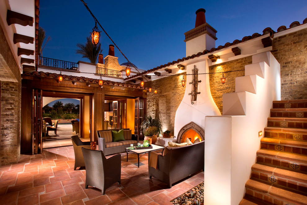 Mediterranean courtyard patio in Los Angeles with tile, no cover and with fireplace.