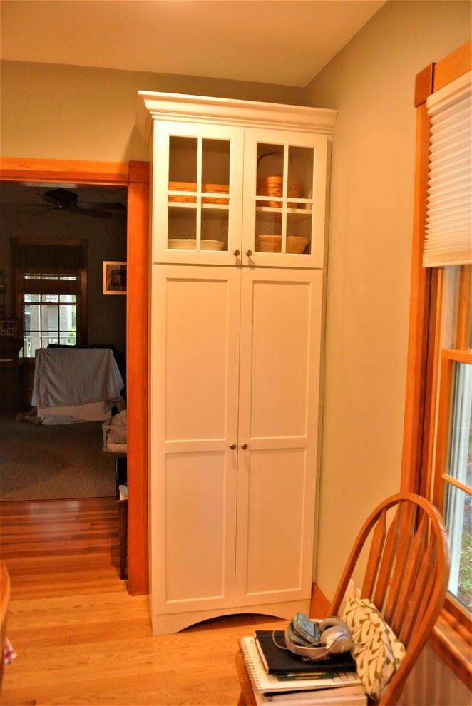 Inspiration for a transitional light wood floor kitchen remodel in Boston with an undermount sink, shaker cabinets, white cabinets, quartzite countertops, white backsplash, subway tile backsplash, stainless steel appliances and an island