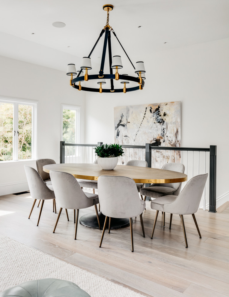 This is an example of a transitional dining room in San Francisco with white walls, light hardwood floors, no fireplace and beige floor.