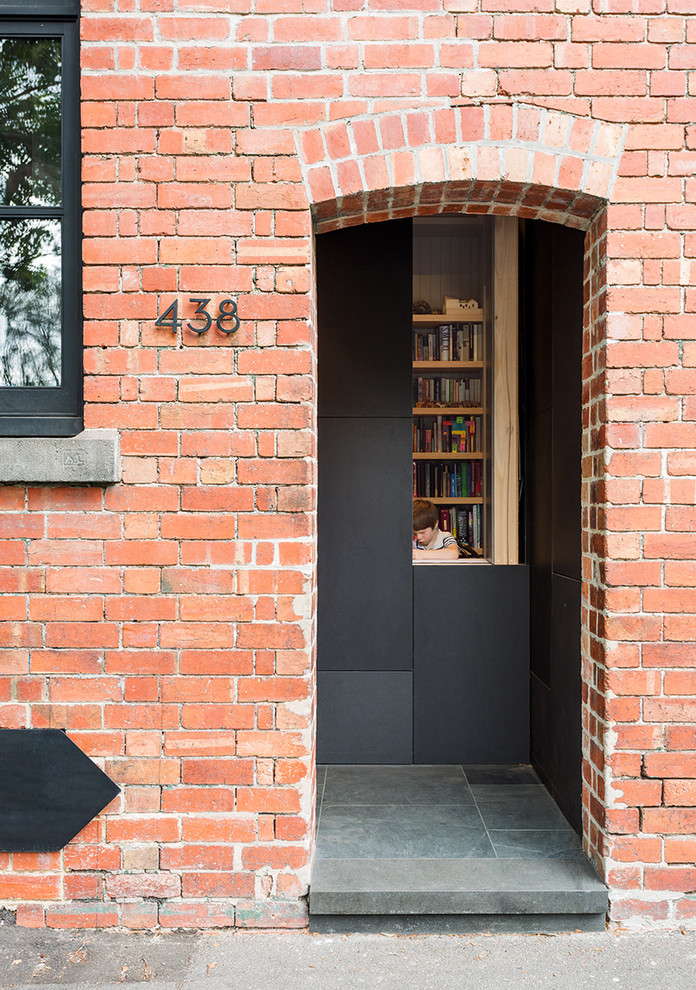 Inspiration for a small industrial three-storey brick red townhouse exterior in Melbourne.