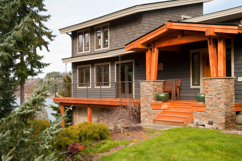 Photo of a large arts and crafts two-storey grey exterior in Seattle with mixed siding and a gable roof.