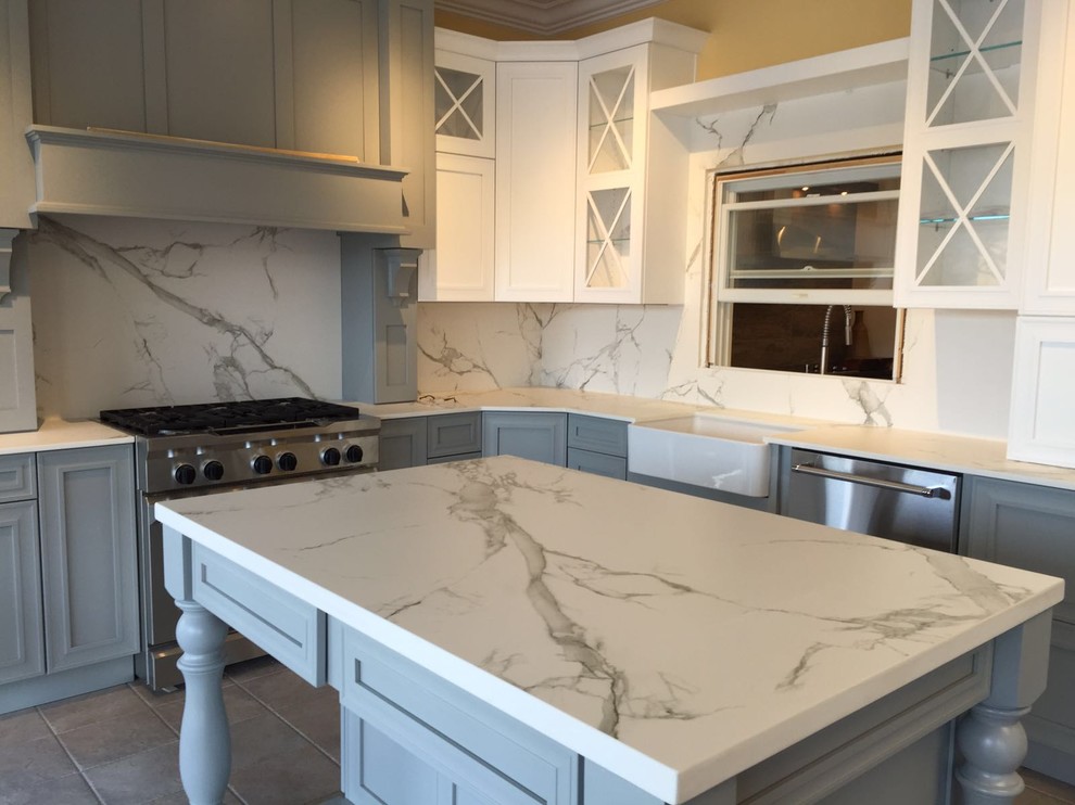 Inspiration for a large farmhouse l-shaped porcelain tile enclosed kitchen remodel in DC Metro with a farmhouse sink, stainless steel appliances, an island, shaker cabinets, white cabinets, marble countertops and stone slab backsplash
