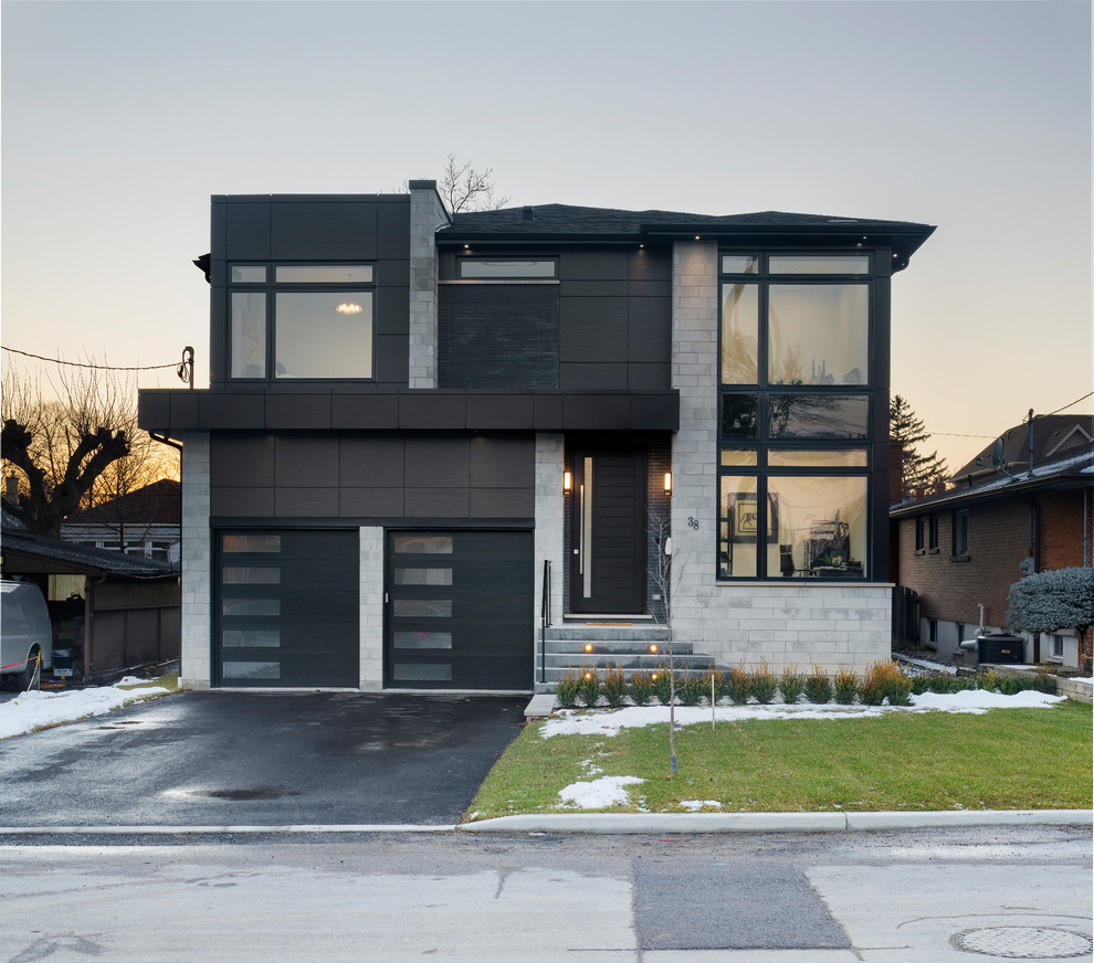 Photo of a contemporary two-storey black house exterior in Toronto with mixed siding, a hip roof and a shingle roof.