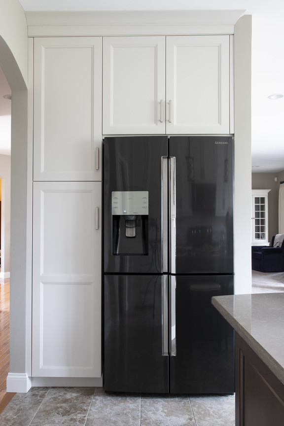 Kitchen - transitional porcelain tile and beige floor kitchen idea with an undermount sink, beige backsplash, black appliances and an island