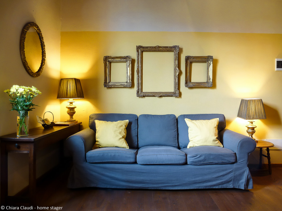 Immagine di un soggiorno chic con libreria, pareti bianche, nessun camino e pavimento grigio