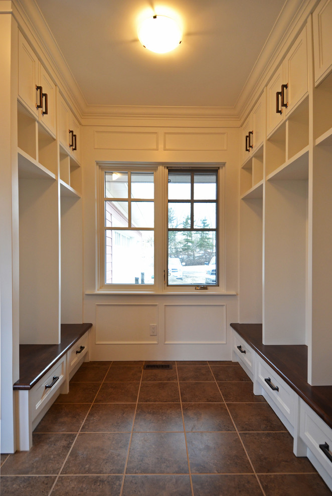 Inspiration for a mid-sized traditional mudroom in Calgary with white walls.
