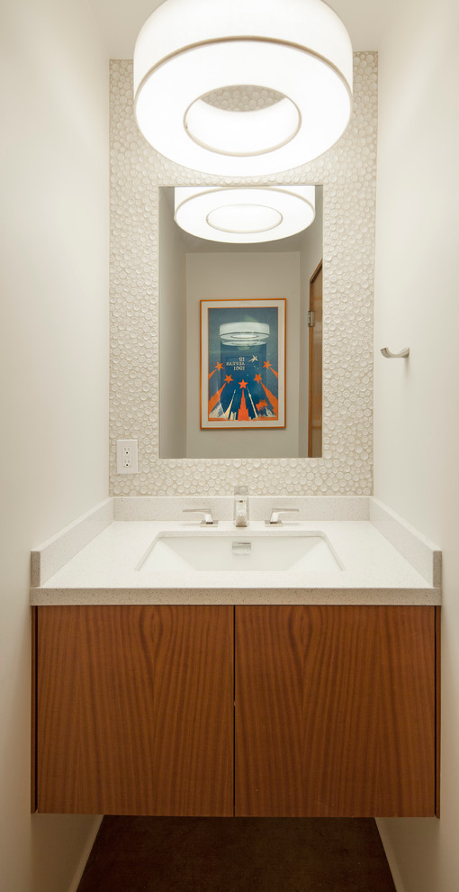 Photo of a mid-sized midcentury 3/4 bathroom in Los Angeles with flat-panel cabinets, medium wood cabinets, a two-piece toilet, white tile, glass tile, white walls, concrete floors and an undermount sink.