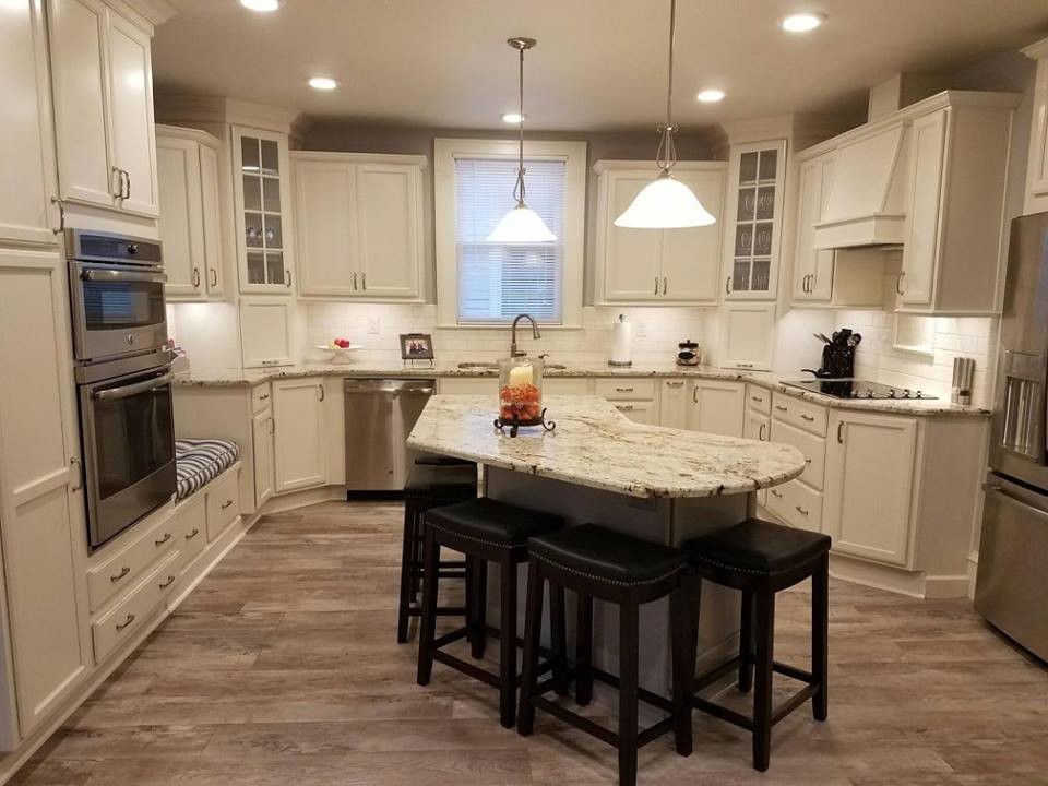 Photo of a mid-sized traditional u-shaped eat-in kitchen in Raleigh with an undermount sink, flat-panel cabinets, beige cabinets, granite benchtops, beige splashback, porcelain splashback, stainless steel appliances, vinyl floors and with island.
