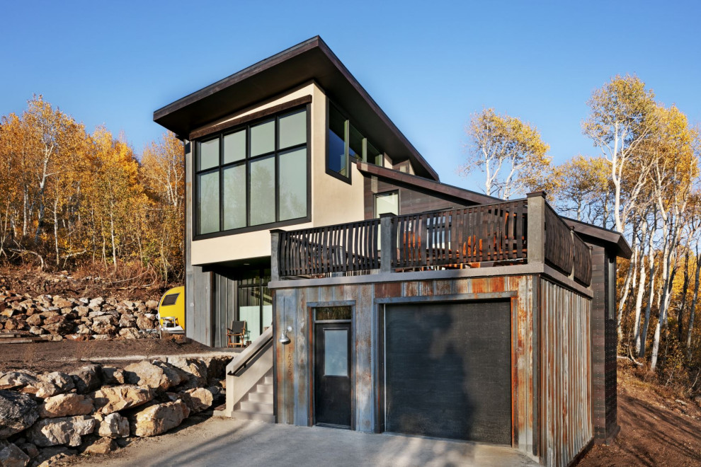 Kleines Modernes Einfamilienhaus mit Betonfassade, grauer Fassadenfarbe, Pultdach, Blechdach, schwarzem Dach und Wandpaneelen in Sonstige