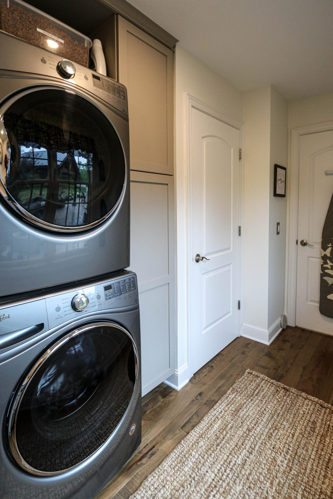 Inspiration for a small transitional u-shaped dedicated laundry room in Cleveland with recessed-panel cabinets, grey cabinets, quartz benchtops, white splashback, shiplap splashback, grey walls, a stacked washer and dryer and white benchtop.