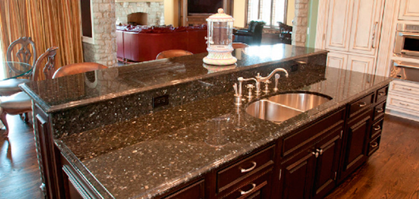 Medium tone wood floor eat-in kitchen photo with a double-bowl sink, recessed-panel cabinets, granite countertops and an island