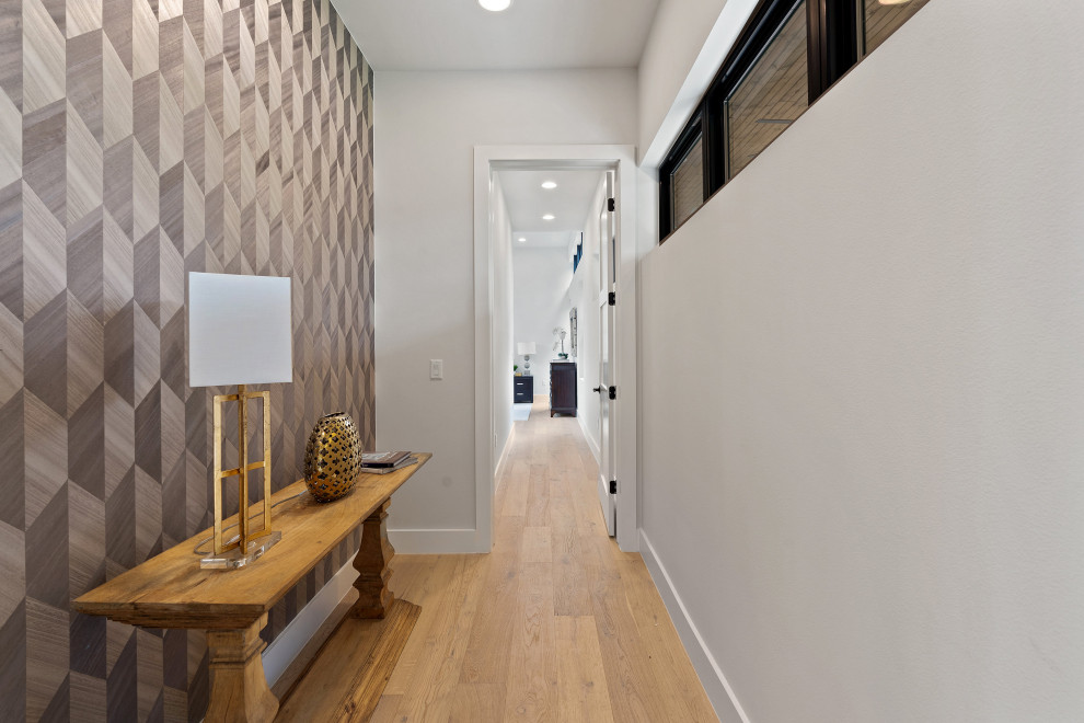 Imagen de recibidores y pasillos minimalistas de tamaño medio con paredes blancas, suelo de madera clara y papel pintado