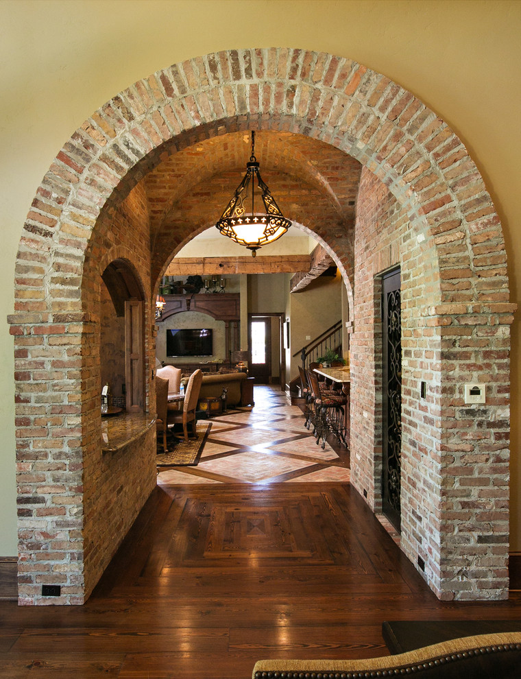 This is an example of a mediterranean hallway in New Orleans with beige walls and dark hardwood floors.