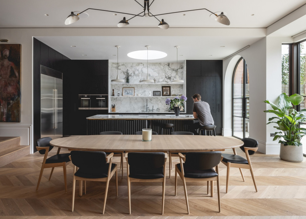 Inspiration for a contemporary kitchen/dining room in London with white walls, light hardwood flooring and beige floors.